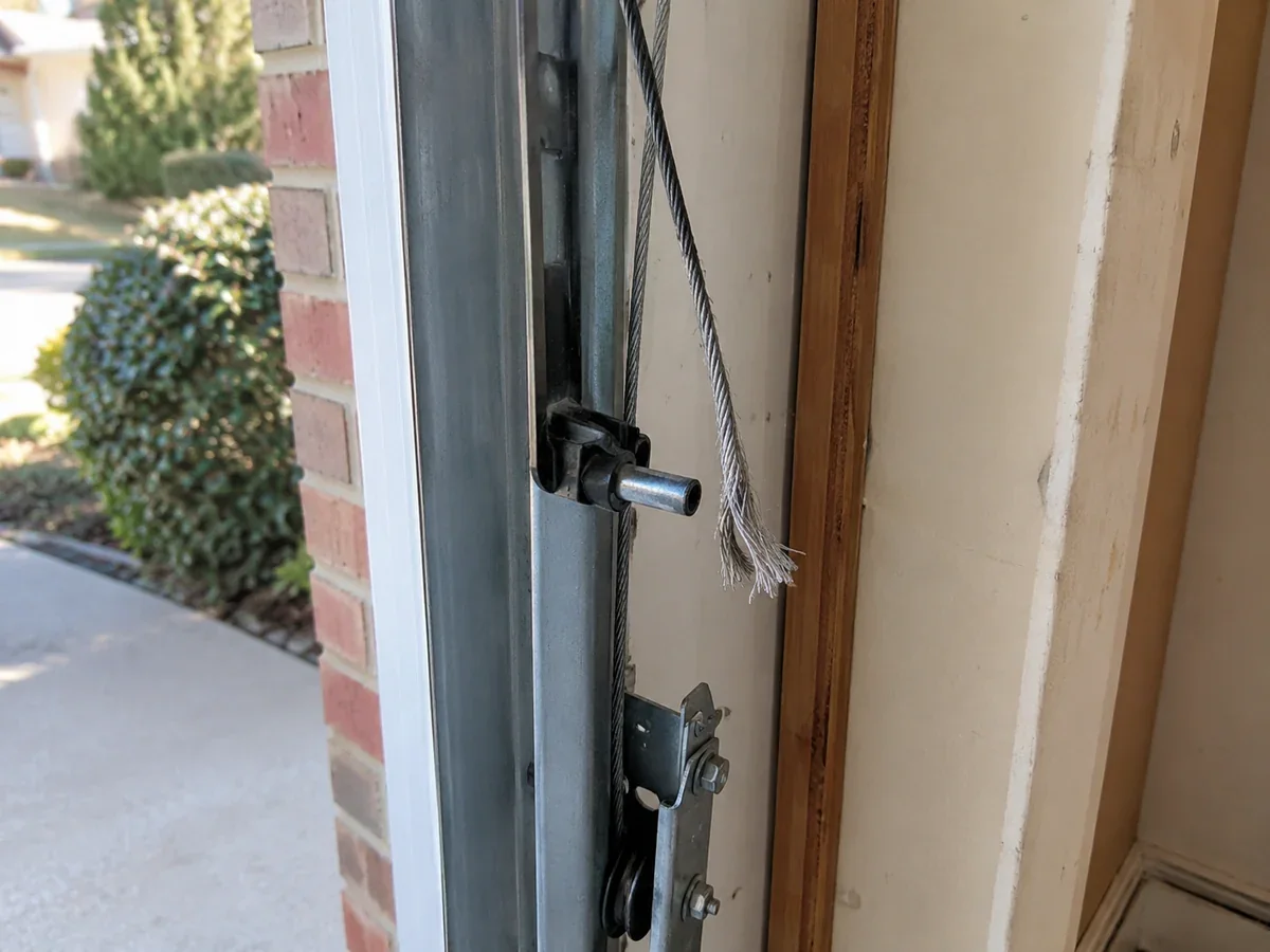 Frayed and snapped garage door cable hanging loose