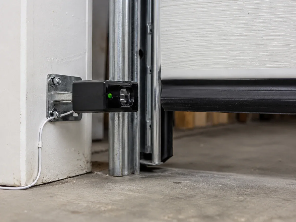 Garage door opener photo-eye safety sensor mounted near the floor